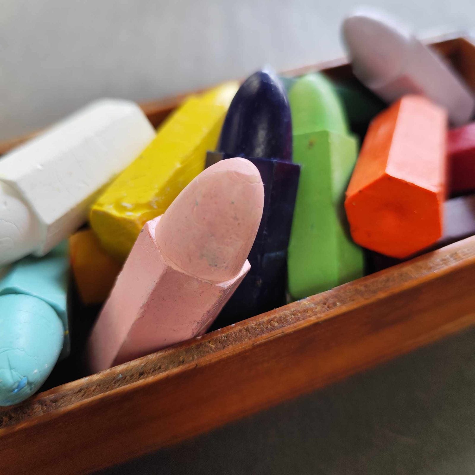 Close up of the six-sided ends of chunky crayons in a wooden tray